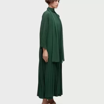 Vestido longo verde escuro com gola alta e mangas plissadas.