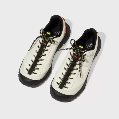 Par de sapatilhas brancas e pretas com atacadores e texto OSKLEN