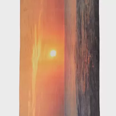 Toalha de praia com imagem de pôr do sol sobre o mar