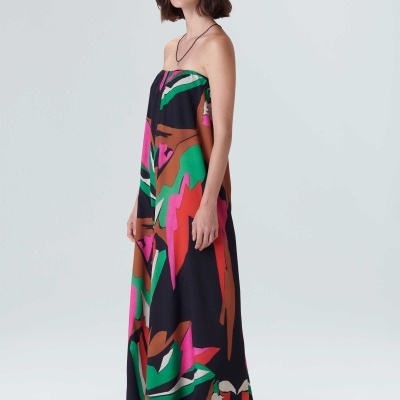 Vestido comprido colorido com chapéu de palha e sandálias em fundo branco