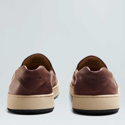 Ténis castanhos OSKLEN vistos de trás com sola bege e base preta