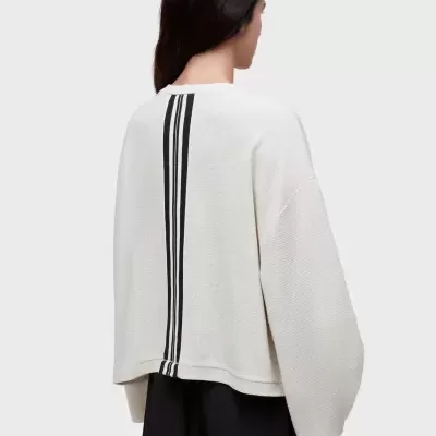 Camisola branca com riscas pretas nas costas e calções pretos.