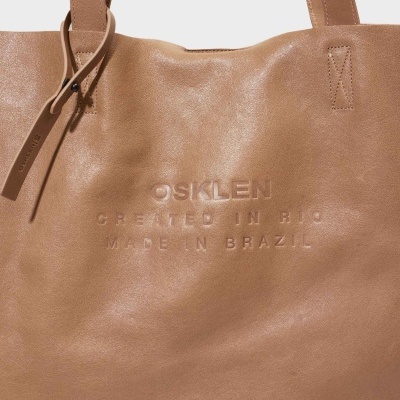 Mala de couro castanho claro com texto gravado e alças largas