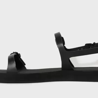 Sandália preta com tiras grossas e sola plana espessa em fundo cinza claro