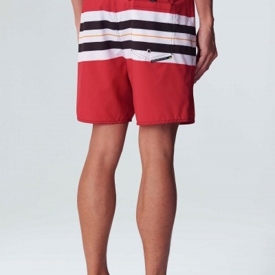 Calções de banho vermelhos com riscas e bolsos vistos de costas