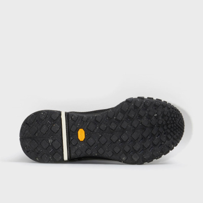 Sola preta antiderrapante de sapato com etiqueta amarela Vibram.