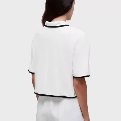 Top branco com detalhes pretos visto de costas em modelo