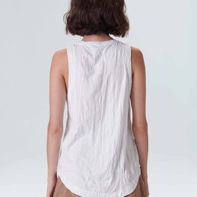 Modelo vista de costas a usar camisola branca sem mangas e calções castanhos