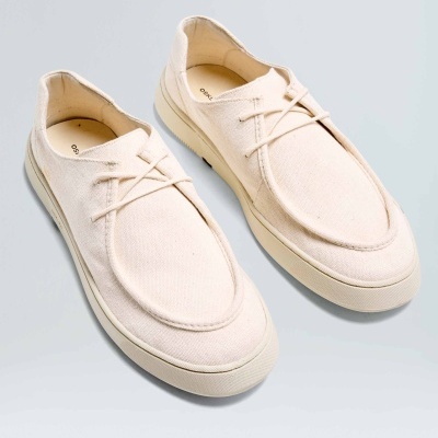 Sapatilhas creme com atacadores e sola branca, design casual.