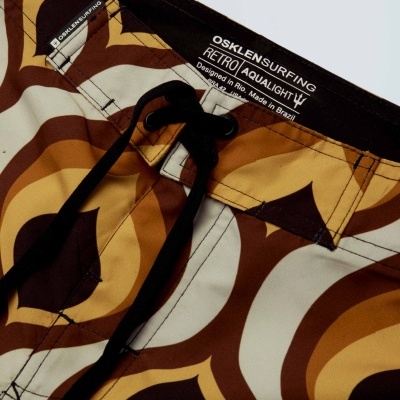 Calções de banho com padrão retro castanho e amarelo, cordão preto e etiquetas visíveis