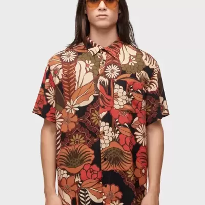 Camisa de manga curta com padrão floral em tons castanhos, vermelho e verde