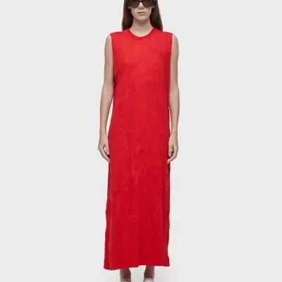 Vestido longo vermelho com padrão texturado usado por mulher com óculos escuros