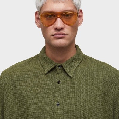 Pessoa com camisa verde e óculos de sol laranja