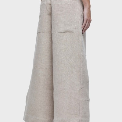 Calças largas bege claro com bolsos grandes e sandálias pretas abertas