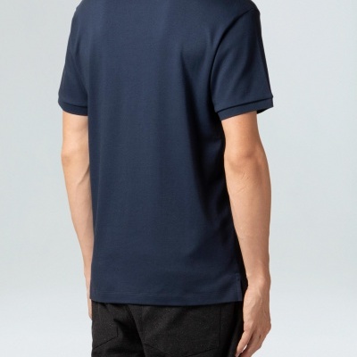 Homem de costas com polo azul escura e calças pretas