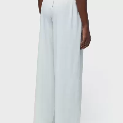 Calças brancas largas com cintura elástica vistas de costas