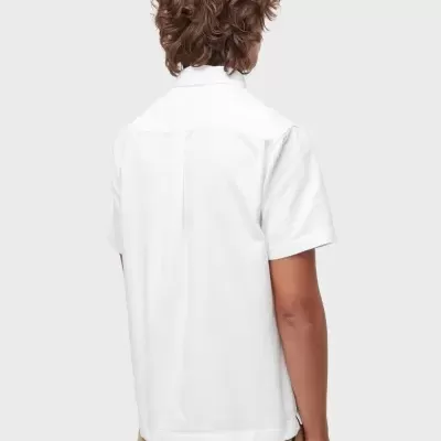 Camisa branca de manga curta vista de trás usada com calças bege estampadas.