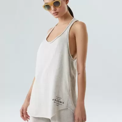 Mulher com top bege claro e óculos de sol amarelos