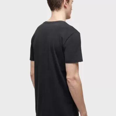 Homem visto de costas a usar t-shirt preta lisa e calças pretas com riscas brancas.