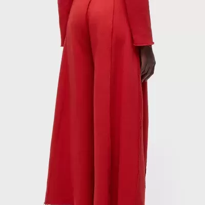 Calças largas vermelhas femininas com bainha desfocada e ténis brancos e vermelhos