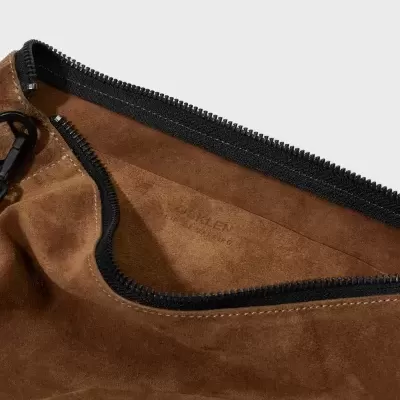Interior de saco ou mochila castanha em camurça com fecho preto e texto ORXALEN