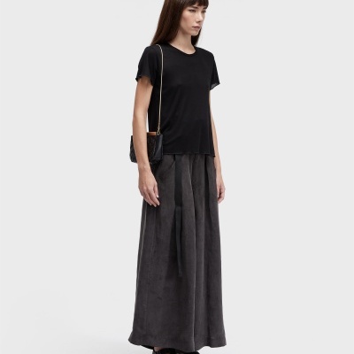 Mulher com roupa casual preta e cinza em fundo branco