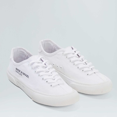 Sapatilhas brancas de tecido com sola e atacadores brancos