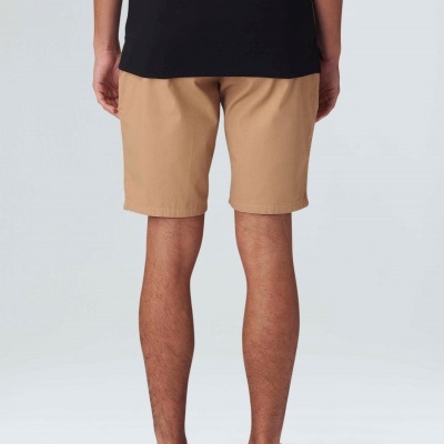 Homem visto de trás usando calções beges, t-shirt preta e ténis pretos OSKLEN