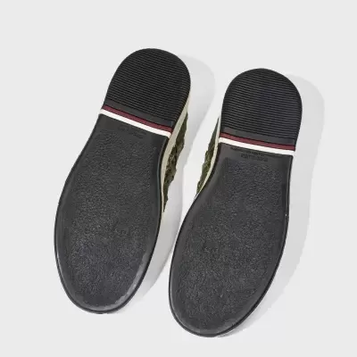 Solados pretos de sapatos com detalhes branco e vermelho vistos por baixo