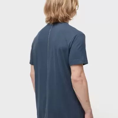 T-shirt azul escuro com costura vertical nas costas e calças bege