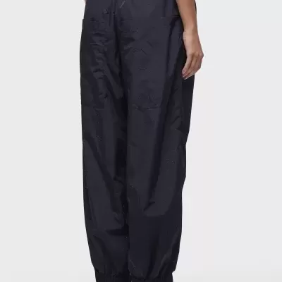 Calças desportivas pretas com ténis negros e brancos vista de costas