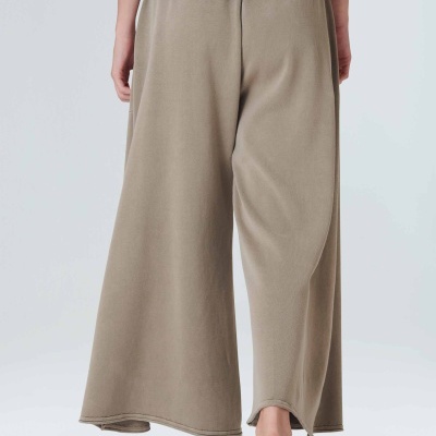 Calças largas caqui de tecido macio vistas de trás em fundo cinzento