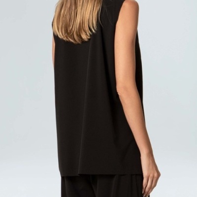 Mulher vista de costas com colete preto e calças largas pretas