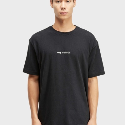 Homem a usar uma camisola preta com texto branco MADE IN BRAZIL