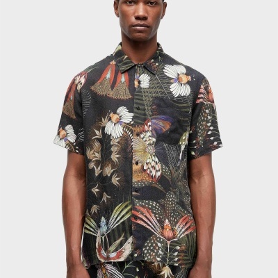 Homem com camisa e calções florais coloridos em fundo preto