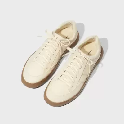 Ténis creme com sola castanha e atacadores iguais em fundo branco