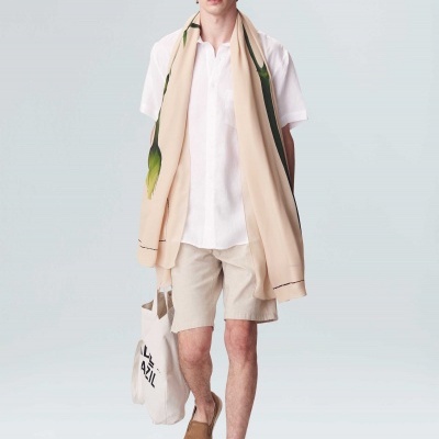 Homem com roupas claras e acessórios em fundo branco