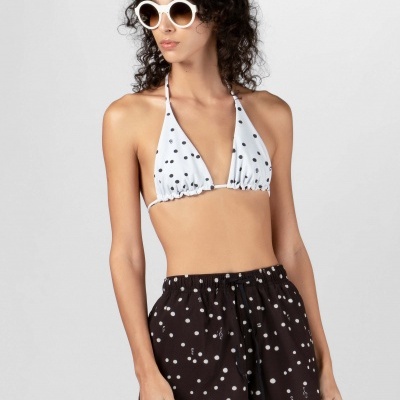 Mulher com bikini triângulo branco de bolinhas pretas e calções pretos de bolinhas brancas