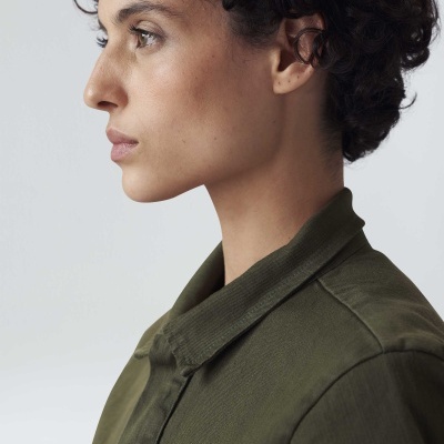 Mulher visto de perfil com casaco verde-oliva de gola clássica