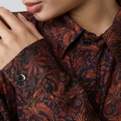 Camisa feminina floral castanha com botões negros em fundo preto
