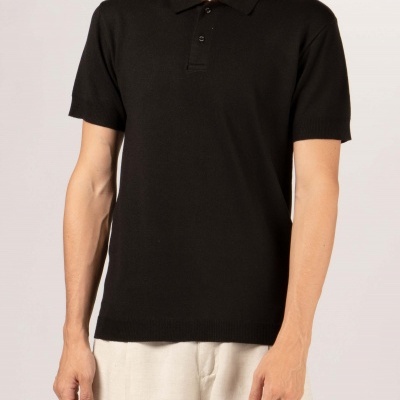 Homem com t-shirt polo preta e calças claras