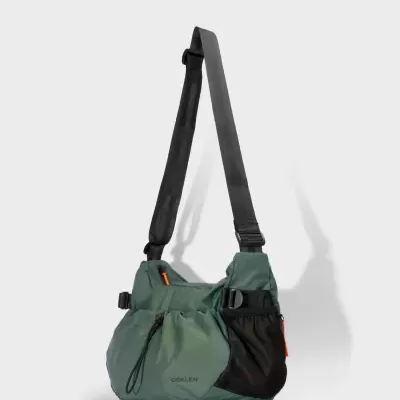 Saco de ombro verde com bolso em rede preto e alça ajustável preta.