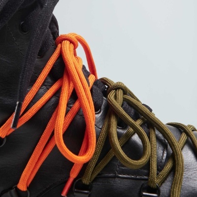 Bota preta com atacadores laranja e verde militar