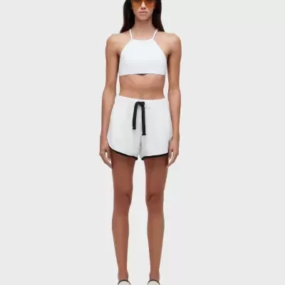 Mulher com roupa desportiva branca e óculos de sol castanhos