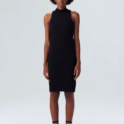 Pessoa com vestido preto justo sem mangas e gola alta, em fundo claro