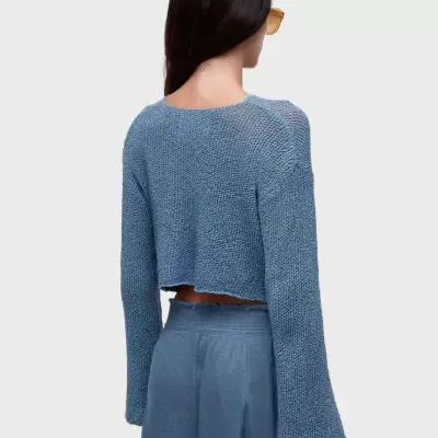 Camisola de malha azul de manga comprida e calças largas azuis vistas de costas.