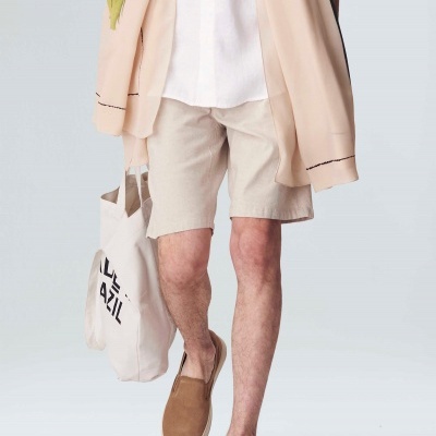 Pessoa com roupa casual clara e mala de tecido com texto preto