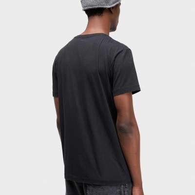 Homem de costas com camisola preta, calças cinza e gorro cinzento