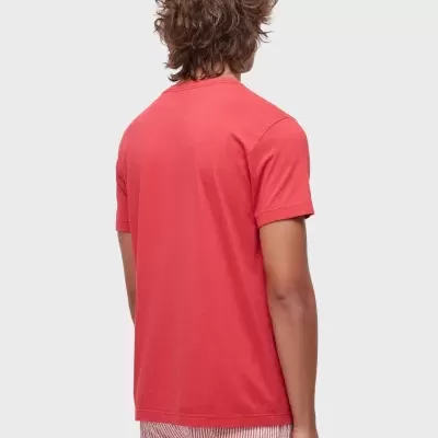 Homem de costas com t-shirt vermelha e calções riscado vermelho e branco