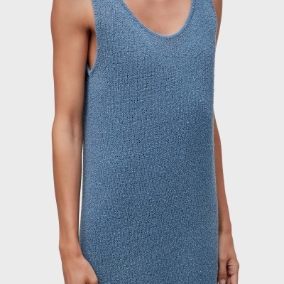 Vestido azul claro de malha com textura usada por mulher em fundo branco